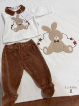 Completo neonato marrone e bianco accanto a coperta con coniglietto