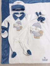 Tutina bianca e blu con accessori su coperta coordinata